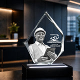 A custom clear acrylic award crystal sculpture on a black LED base, featuring The crystal is displayed in a modern, dark-toned office lobby. corporate gift, colleague gift, gift ideas, buy an award, corporate gift ideas, 3d crystal photo, 